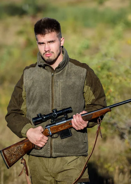 Bearded serious hunter spend leisure hunting. Man brutal unshaved gamekeeper nature background. Hunting permit. Hunter hold rifle. Hunting is brutal masculine hobby. Hunting and trapping seasons