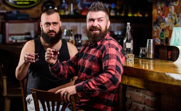 Bebidas alcohólicas fuertes. Amigos relajándose en el pub. Viernes relajarse en el pub. Concepto de salud. Hipster brutal barbudo bebiendo alcohol con un amigo en el mostrador del bar. Hombres borrachos relajándose en el pub divirtiéndose — Foto de Stock