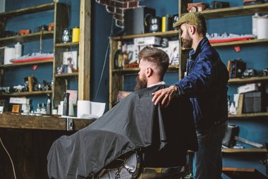 Hipster istemci yeni saç kesimi var. Sakallı adam aynaya, berber arka plan seyir ile berber. Saç kesimi kavramı. İstemci ve profesyonel master kontrol sonucu. Kuaför kesme bitmiş
