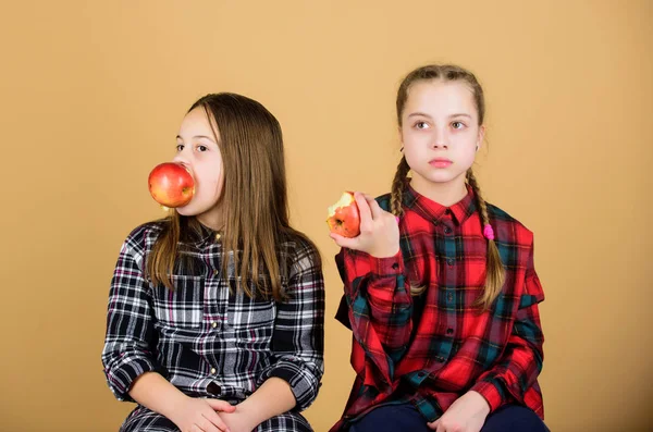 Τρώτε φρούτα για να χαριτωμένο. Μικρά κορίτσια τρώνε μήλα μαζί. Κοριτσάκια να απολαύσετε φρέσκα φρούτα. Χαριτωμένα κορίτσια τρώει υγιεινά σνακ. Αξιολάτρευτο κορίτσια με φυσικές τροφές — Φωτογραφία Αρχείου