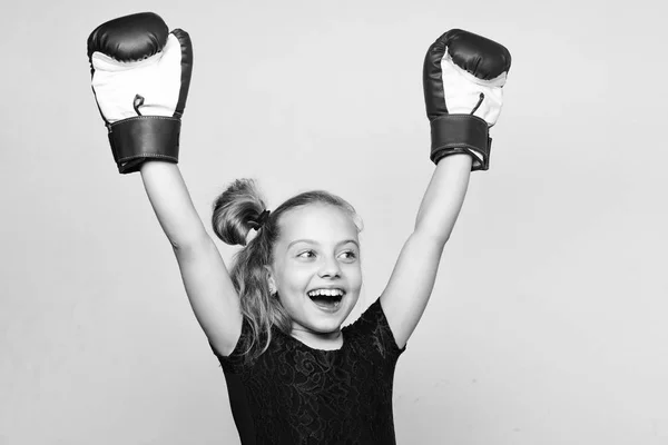 Niña ganadora feliz con guantes de boxeo posando sobre fondo gris. Movimiento feminista. Se siente como ganadora. Crianza para el liderazgo y el ganador. Fuerte niño orgulloso ganador concurso de boxeo — Foto de Stock