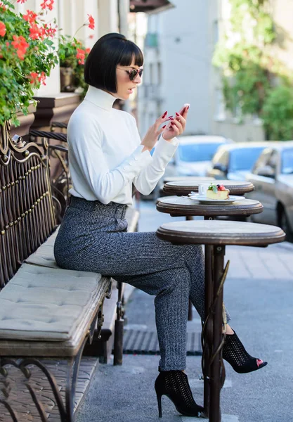 Hubungi teman. Konsep waktu luang. Gadis modis wanita dengan smartphone. Wanita cantik berambut coklat menghabiskan waktu luang kafe teras latar belakang. Waktu yang menyenangkan dan kesenangan. Santailah dan istirahat — Stok Foto