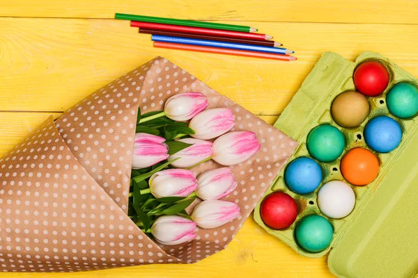 Spring holiday. Holiday celebration, preparation. painted eggs in egg tray. Tulip flower bouquet. Healthy and happy holiday. Happy easter. Egg hunt. Excited about Easter