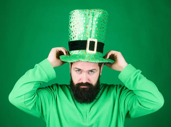 The raising of the green. Hipster in leprechaun costume touching hat. Irish man with beard wearing green. Bearded man celebrating saint patricks day. Happy saint patricks day Royalty Free Stock Photos