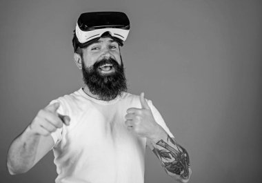 Sakal ve bıyık Vr gözlük, mavi arka plan ile olan adam. VR teknolojisi kavramı. Hipster mutlu yüz ileriye dönük jest ve yukarı gösterir. Adam Vr gözlük veya baş ile görüntü monte