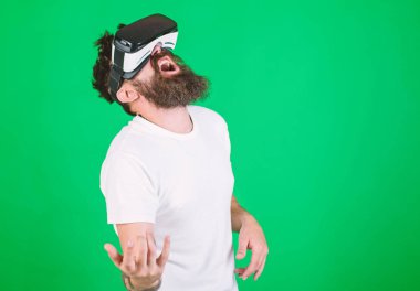 Vr gözlüklü öğrenin gitar müzik çalmak. VR müzisyen kavramı. Vr gözlük, yeşil arka planda sakallı adam. Hipster gitarist hevesli yüzündeki eğlence için modern teknolojisini kullanıyor
