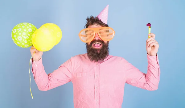 Człowiek z broda i wąsy na szczęśliwy twarz trzyma powietrze balony, jasnoniebieskie tło. Hipster w okulary olbrzym obchodzi urodziny. Facet w party hat z atrybutami wakacje obchodzi. Koncepcja strony — Zdjęcie stockowe