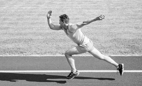 Концепция повышения скорости. Спортсмен-бегун отталкивает стартовую позицию стадиона в солнечный день. Как начать бегать. Гонка бегунов на стадионе. Бегун захвачен в движение сразу после старта гонки
