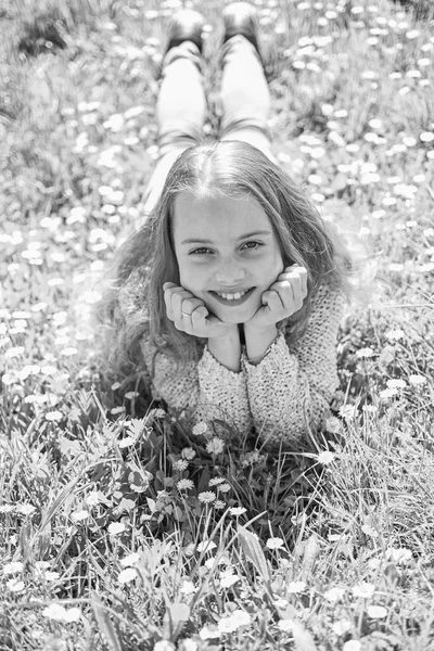 Dziewczyna, leżąc na trawie w trawnik, zielone tło. Dziecko cieszyć się słoneczną pogodę wiosna leżąc na łące. Koncepcja rozkwitu. Dziewczyna na uśmiechniętą twarz spędzić aktywny wypoczynek na świeżym powietrzu — Zdjęcie stockowe
