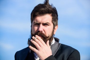 Rahat hissediyor. İş adamı gökyüzüne karşı. Gelecekteki başarısı. Erkek resmi moda. Sakallı adam sigara içiyorum. duman. Bıyıklı acımasız beyaz hippi. Olgun hipster sakallı