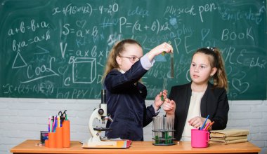 Little girls scientist work with microscope. Little girls in school lab. Science is future. science experiments. Chemistry research. Biology science. Happy little girls. Developing new approaches clipart