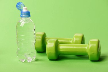 Su şişesi hafif halterlerin yanında, yaklaşın. Atletizm kavramı