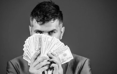 Kolay nakit krediler. İşadamı nakit para var. Zenginlik ve refah kavramı. Nakit para kolay ve hızlı bir şekilde almak. Para gibi kokuyor. Resmi takım elbise tutun doları banknot yığını mavi arka plan