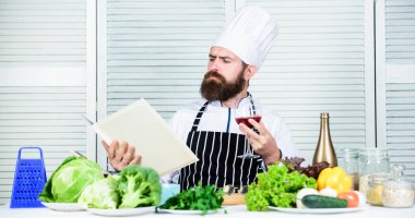 Biraz alkol ekle. Usta şef bir bardak şarap tutuyor. Yemekte hangi şarap servis ediyor? Enfes bir akşam yemeği konsepti. Şarap arıtma. Şarap ve yemeği uzman gibi eşleştir. Erkekler şapka takar ve önlük giyer.