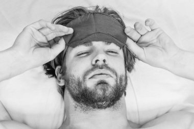 Yatakta uyanma ve kollarını uzanan bir delikanlı. Çıplak ayak altından cove bakmak bir adam. Uyanma sırasında esneme adam.