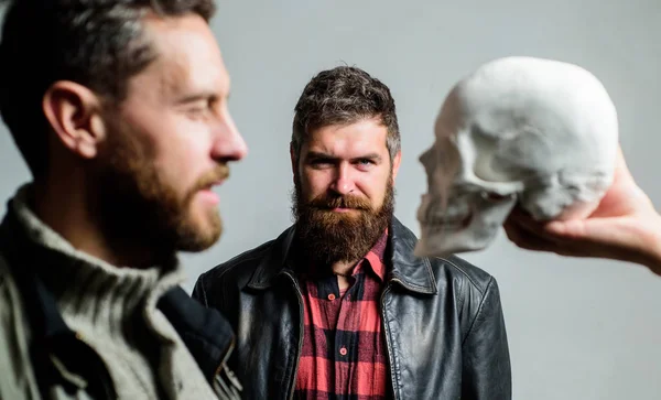 Overcome your fears. Be brave. Focused on breaking fear. Psychology concept. Human fears and courage. Looking deep into eyes of your fear. Man brutal bearded hipster looking at skull symbol of death