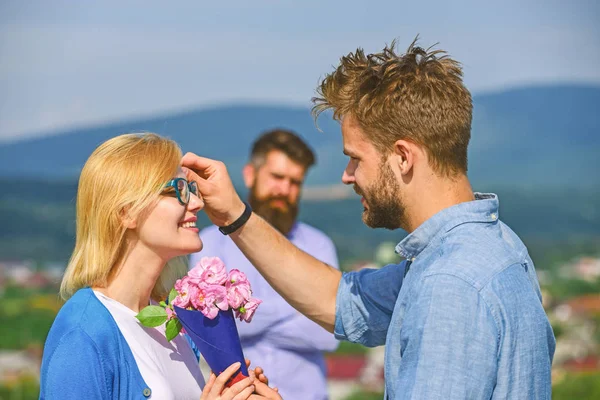 Para zakochanych, celownik podczas gdy zazdrosny mąż oglądania nieruchomo na tle. Koncepcja niespełnionej miłości. Miłośników zewnątrz flirt romans stosunków. Para romantyczny daty kochanka obecny bukiet kwiatów — Zdjęcie stockowe