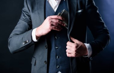Brandy içeceği. Adam alkol içiyor. Erkek, brendi şişesini cebine koydu. Bekar ve bekar. Erkek olanın kötü bir bağımlılığı var, brendi. Takım elbiseli iş adamı. Brendi sever. Cesur olmak için alkole ihtiyacım var.