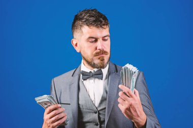 Nakit kolay ve hızlı bir şekilde olsun. Nakit işlem iş. Resmi takım elbise mavi arka plan doları banknot yığını tutun. Kolay nakit krediler. Zenginlik ve refah kavramı. İşadamı nakit para var.