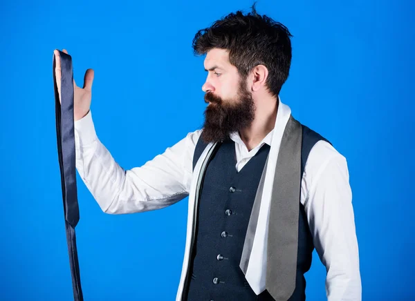 Um tipo com barba a escolher gravata. Cavalheiros guia. Como escolher o laço certo. Estilo clássico. Como combinar gravata com camisa e terno. Homem barbudo hipster segurar algumas gravatas no fundo azul — Fotografia de Stock