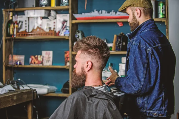 Hipster-Klient bekam neuen Haarschnitt. Friseur mit bärtigem Mann, der in den Spiegel schaut, Barbershop-Hintergrund. Haarschnitt-Konzept. Friseur fertig gestylt. Ergebnis der Kunden- und professionellen Meisterprüfung — Stockfoto