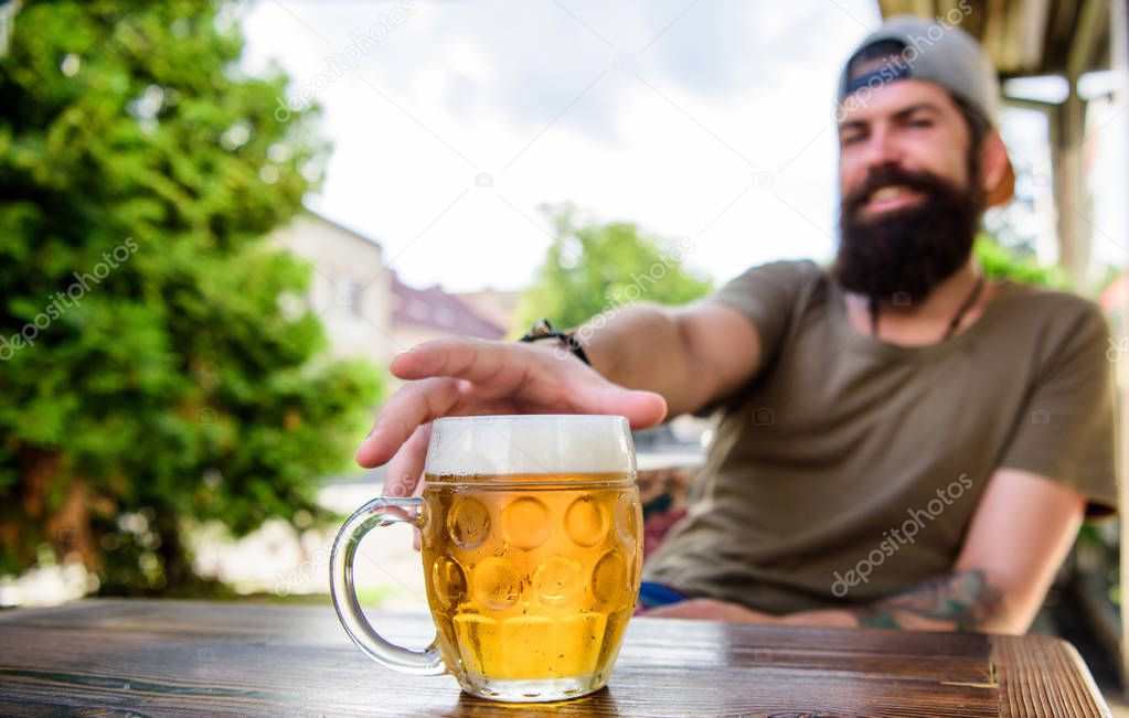 Enjoying non alcoholic beer. Bearded man grabbing alcoholic drink in bar. Hipster sitting with alcoholic beverage in pub. He is a social drinker not an alcoholic