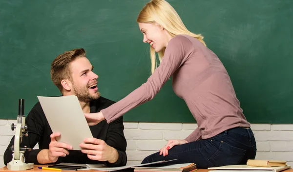 Hier sind Informationen, die wir brauchen. hübsche Lehrerin und gut aussehende Schulmeisterzeugnisse. Gymnasialausbildung. Universitäts- oder Hochschulstudenten. Mann und Frau zurück in die Schule. Paar lernt im Klassenzimmer — Stockfoto