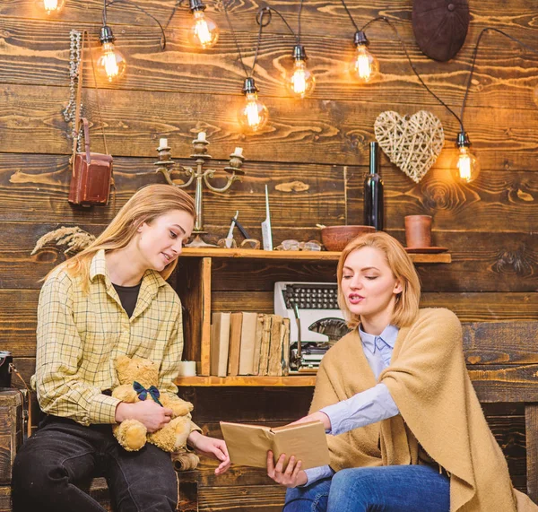 Madre e hija discutiendo el libro. Mujer explicándole algo a una adolescente rubia, maternidad y concepto de crianza. Chica en traje de niño sosteniendo oso de peluche. Mamá y el niño pasar tiempo juntos — Foto de Stock