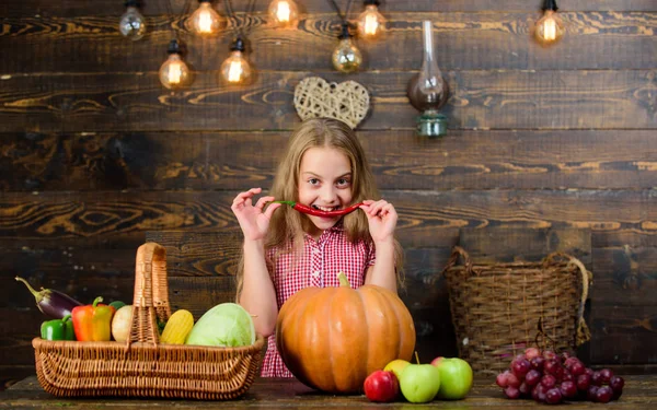 Farm themed games and activities for kids. Girl kid at farm market with fall harvest. Child little girl celebrate harvesting. Family farm festival concept. Kid farmer with harvest wooden background