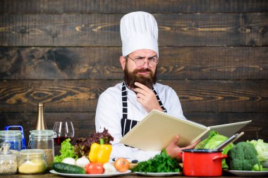Profesyonel şef aşçı üniformalı. Mutfakta yemek mutlu sakallı adam. Organik gıda ile diyet. Taze sebze. Sağlıklı gıda ve vejetaryen. Vitamini. adam kullanımı mutfak eşyaları. Sağlıklı yemek