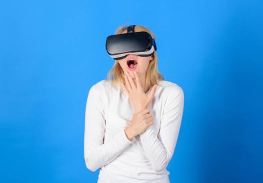 Sanal gerçeklik giyen kadın mavi arka planda gözlükler. Kadın zevk cyber eğlence deneyimi vr içinde. Genç kadın Vr deneyimi sırasında hava dokunmadan hayran. Teknik ağ.