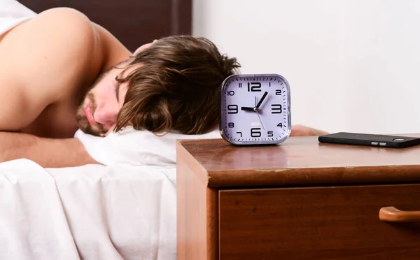 Hombre guapo usando el reloj en la cama después de despertarse por la mañana. Hombre perezoso feliz despertando en la cama levantando las manos por la mañana con sensación fresca relajado. Joven, despierta. . —  Fotos de Stock