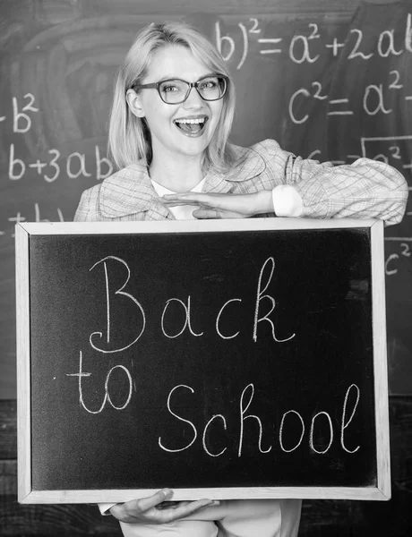 Topp sätt att välkomna eleverna tillbaka till skolan. Lärare kvinna hålla blackboard inskription tillbaka till skolan. Det är skoltid igen. Skola lärare glada att välkomna elever. Bra början av skolan Ja — Stockfoto