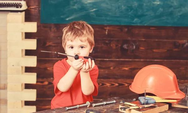 幼儿在繁忙的脸上玩螺丝刀工具在家里的车间。小男孩扮演杂工。童年的概念。儿童可爱和可爱的发挥建设者或维修, 修理或就要手工制作 — 图库照片