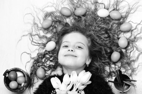 Gelukkig Pasen meisje, kleurrijke eieren in lang haar, tulp bloemen — Stockfoto