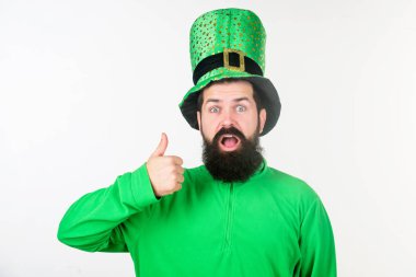 Mutlu saint patricks günü. Hippi cüce şapkası ve ağız açık tutarak kostüm. Sakallı adam Saint patricks günü kutluyor. Yeşil giymiş sakallı İrlandalı adam. Başparmak yukarıya için Aziz patrick