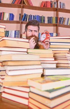 Öğretmen ya da sakal Kitaplığı'nda eğitim ile öğrenci. Adam, çalar saat ile kitap yığınları dışarı bakmak bilim adamı. Adam düşünceli yüz saat, raflardan arka plan üzerinde seyir. Son Tarih kavramı