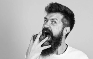 Adam sakal hipster çilek parmak arka plan mavi. Çoğunlukla karbonhidratlar sükroz fruktoz glikoz. Karbonhidrat içeriği çilek. Metabolik hastalık. Çilek en güvenli meyve şekeri için