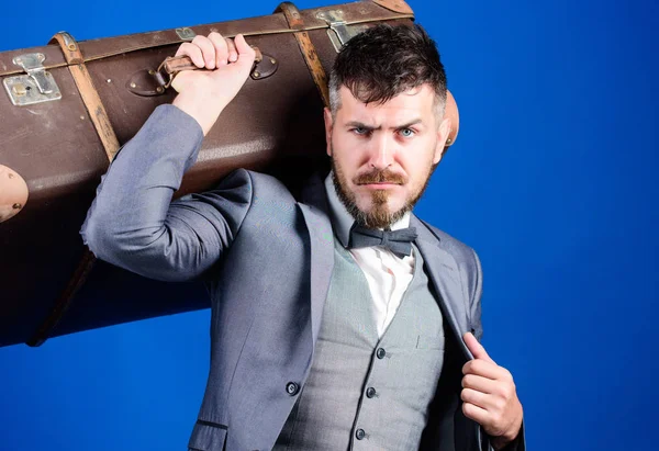 business trip with retro suitcase. stylish esthete with vintage bag. bearded man in formal suit. heavy bag. mature traveller. businessman in bow tie. Ready to new business trip. Stylish handsome man