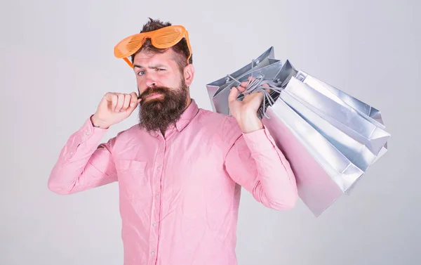 Compras el viernes negro. Feliz compra con bolsas de papel. Consumidor adicto a las compras. Hombre barbudo hipster usar gafas de sol sostienen manojo bolsas de compras. Cómo prepararse para sus próximas vacaciones. —  Fotos de Stock