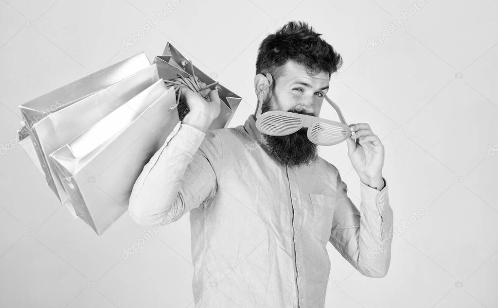 How to get ready for your next vacation. Man bearded hipster wear sunglasses hold bunch shopping bags. Shopping on black friday. Happy shopping with bunch paper bags. Shopping addicted consumer