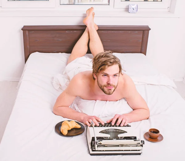 Author having breakfast in bed eat croissant and coffee. Pleasant occupation. Morning inspiration. Man writer lay bed bedclothes working book. Writer romantic author used old fashioned typewriter