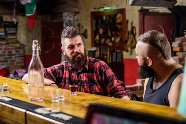 Hombres relajándose en el bar. Bebidas alcohólicas fuertes. Viernes de relajación en el bar. Amigos relajándose en el bar o pub. Interesante conversación. Hipster brutal barbudo pasar el ocio con un amigo en el mostrador de bar — Foto de Stock