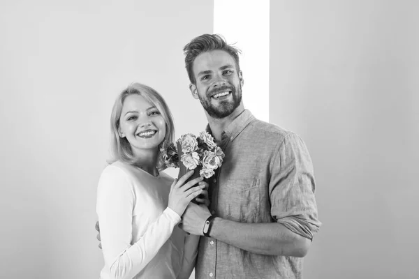 O homem parabeniza as férias de aniversário da mulher, fundo pastel. Conceito de presente. Casal data buquê flores presente. Casal apaixonado celebrando férias. Homem dá flores de buquê para namorada — Fotografia de Stock