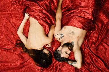 Yarı çıplak vücutlu kadın ve erkek yatak odasında yatıyor.