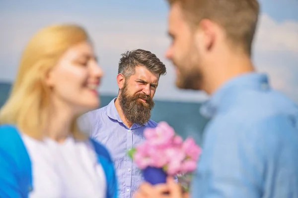 Pareja enamorada feliz citas, hombre barbudo celoso viendo esposa engañándolo con amante. Amantes de la reunión al aire libre coquetear relaciones románticas. Concepto celoso. Pareja romántica cita amantes ramo flores —  Fotos de Stock