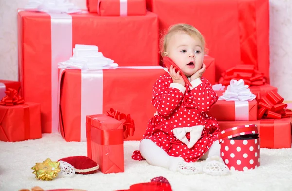Ділитися радістю з дитиною перше Різдво з родиною. Маленька дівчинка грає біля купи подарункових коробок. Подарунки для дитини перше Різдво. Святкуй перше Різдво. Дитяче перше Різдво одного разу в житті — стокове фото