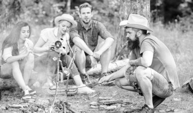 Arkadaş grubu turist şenlik ateşi rahatlatıcı. Arkadaşlar paylaşım izlenim konuşurken sosis Kavurma ve fotoğraflar kamera izlerken bir adam. Atıştırma zamanı olan turistler ile yangın gıda kavrulmuş. Orman zammı