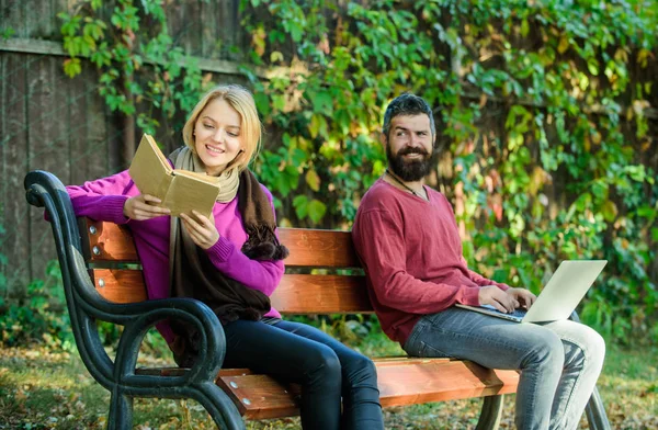 Biblioteca online, e-book. Computer con libri. Vantaggio della tecnologia moderna. Approfitta dello sviluppo tecnologico. e-reader. educazione online. Comunicazione informatica ed e-learning. uomo e donna nel parco — Foto Stock