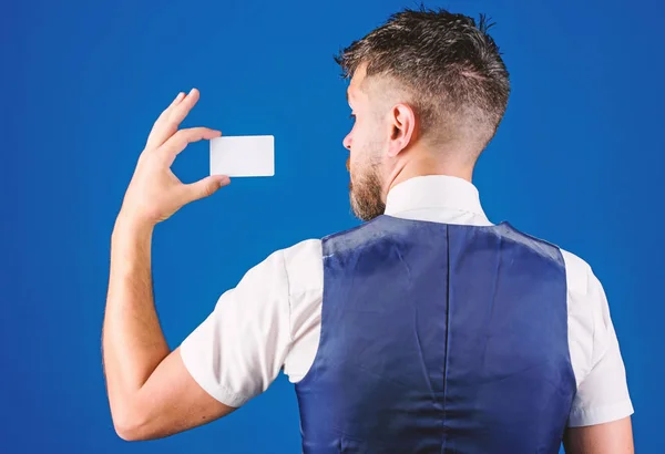 Man hold plastic blank card blue background rear view. Take this card. Banking and credit concept. Plastic bank card. Easy money credit. Which bank credit card is easy to get